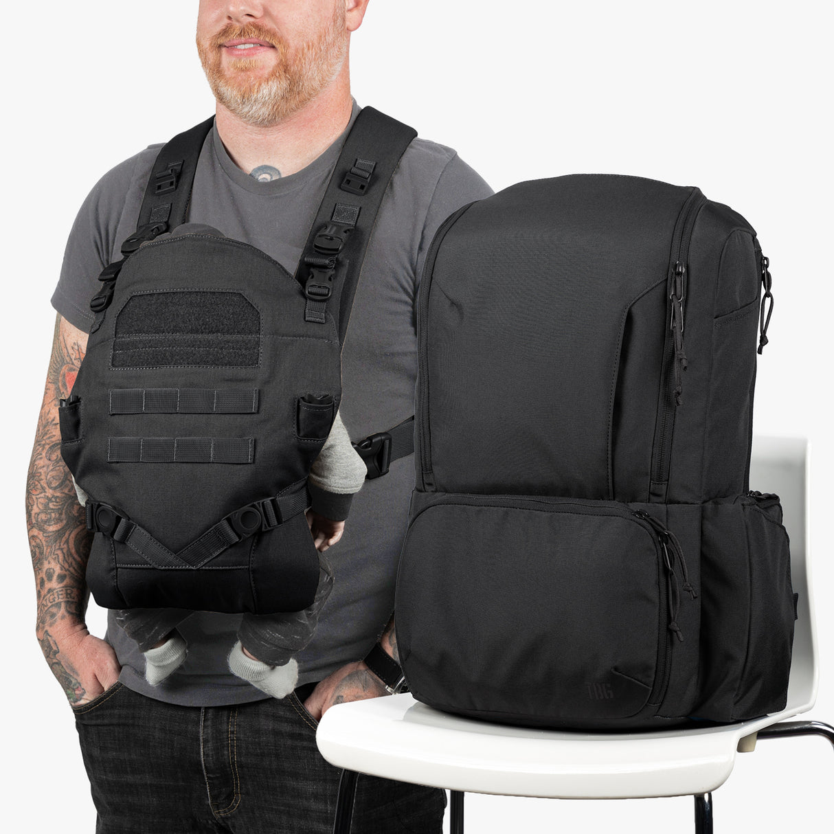 Diaper bag and baby carrier bundle in black, displayed against a plain background, featuring multiple compartments and adjustable straps.