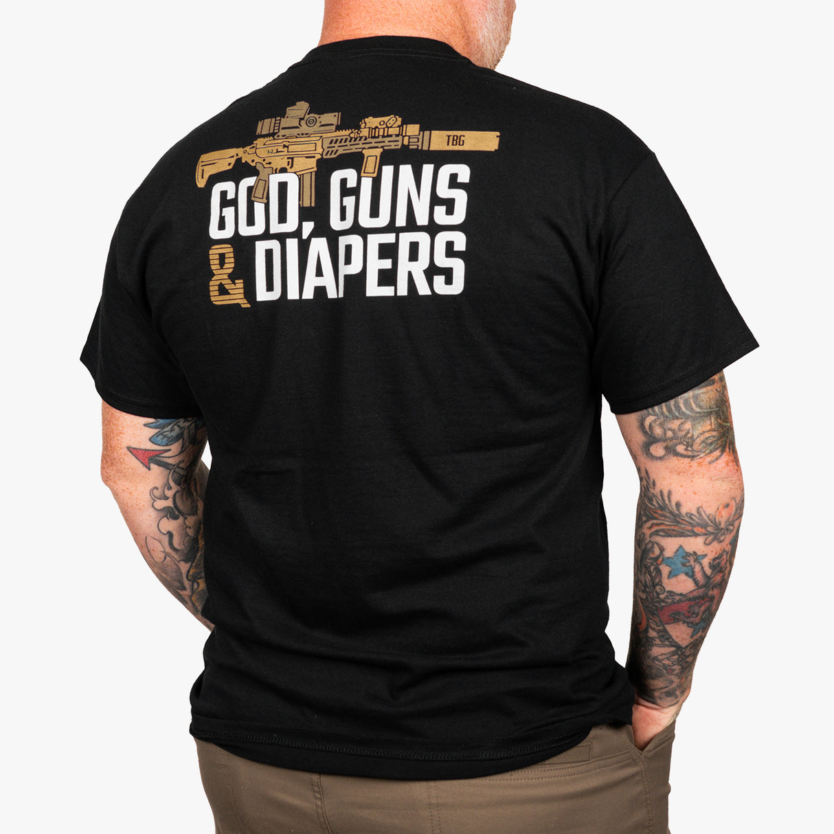 Black t-shirt featuring the phrase "God, Guns & Diapers" with a graphic of a firearm on the back.
