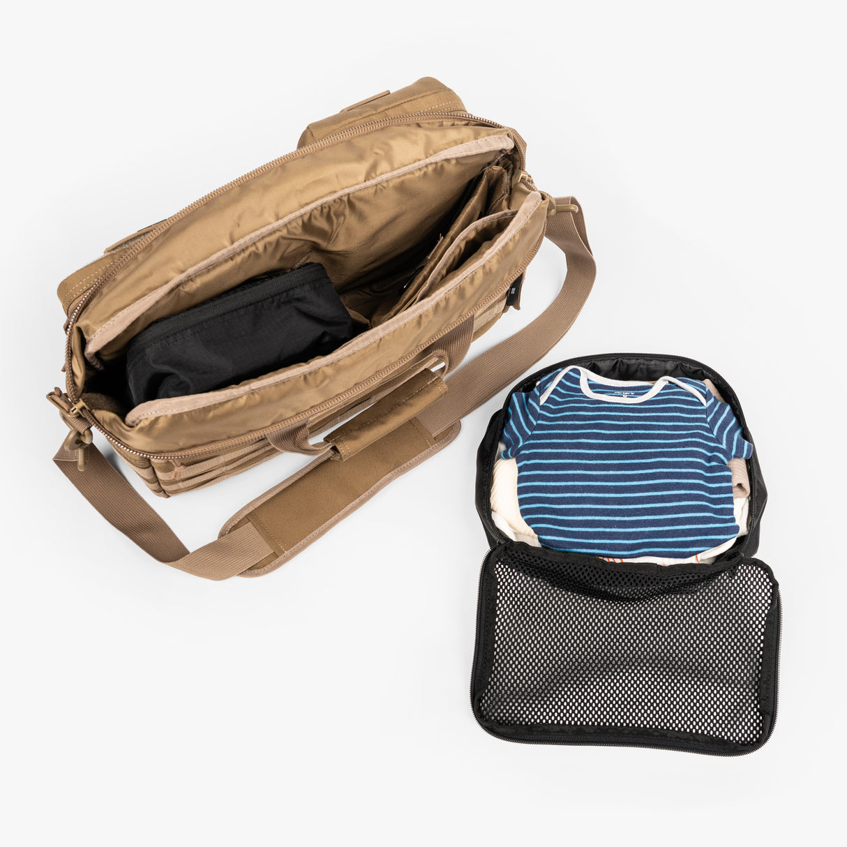 Tactical diaper bag with open compartments and a packing cube containing a striped shirt, showcasing organized storage.