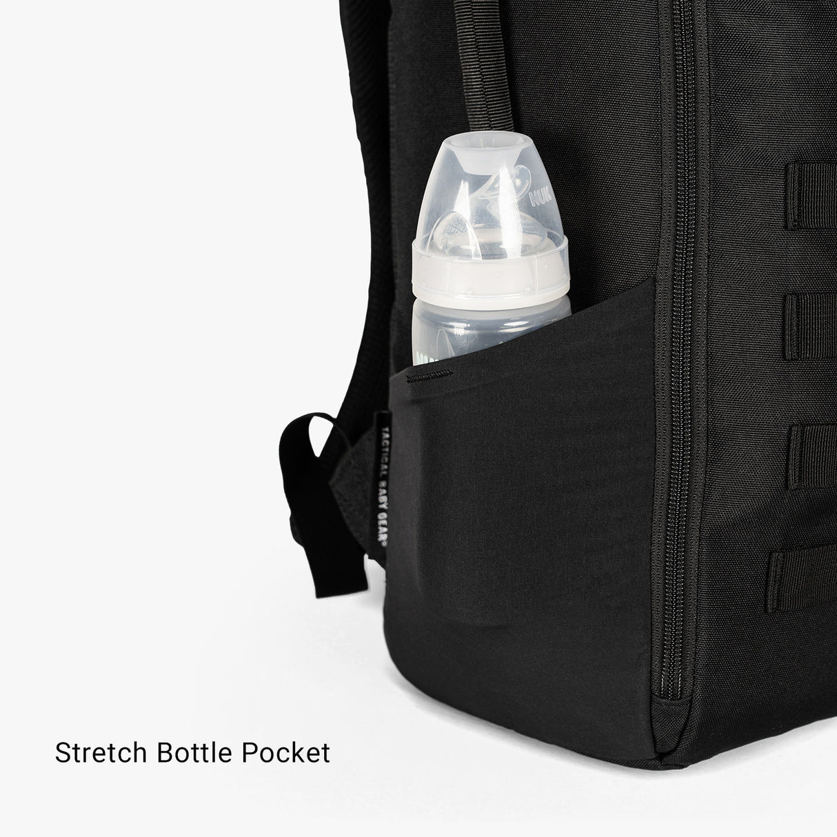 Close-up of the Daypack Mini featuring a stretch bottle pocket holding a baby bottle, showcasing its practical design.
