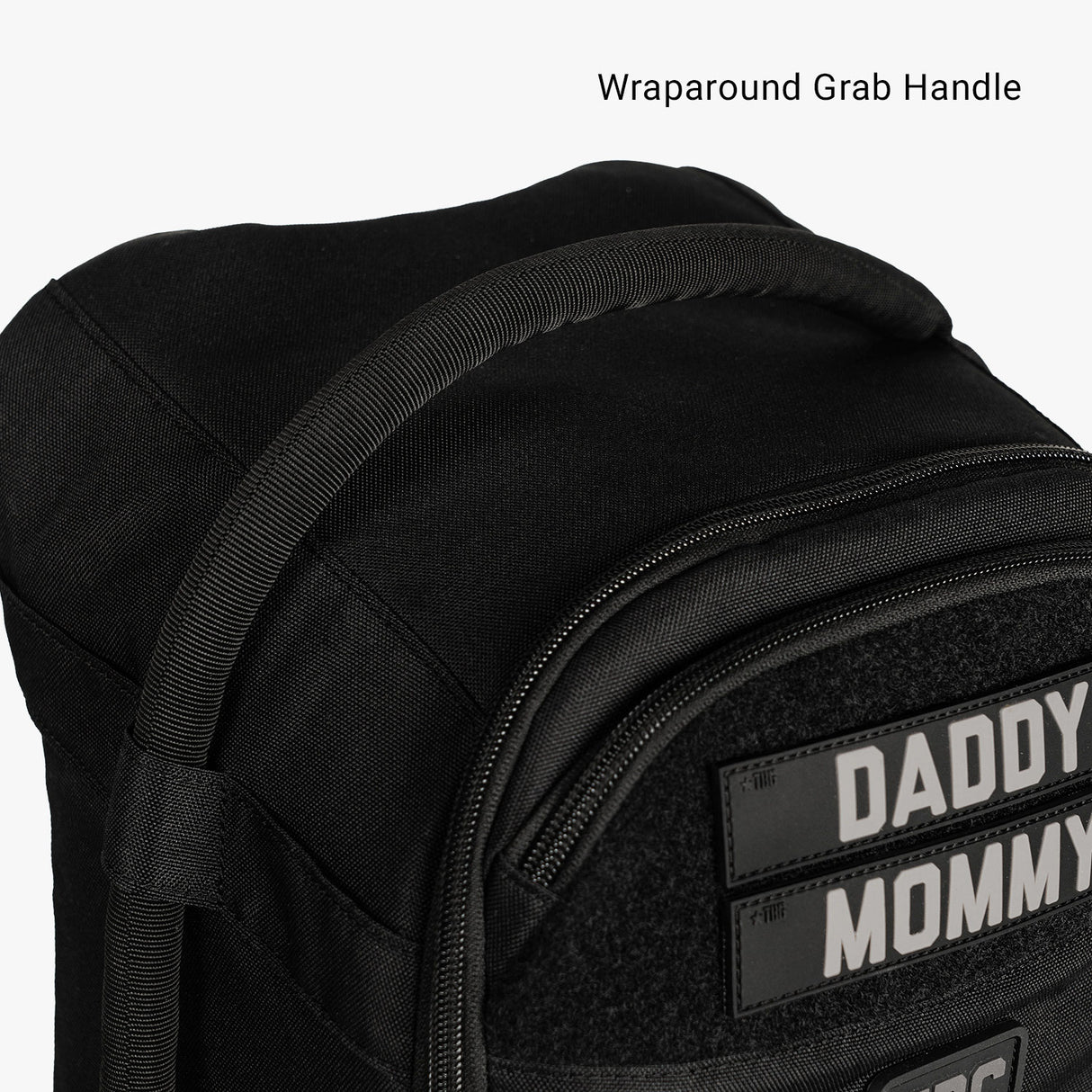 Compact black Daypack Mini featuring a wraparound grab handle and customizable name patches for parents.