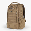 Tactical Baby Gear daypack diaper bag in tan with multiple zippered compartments, MOLLE webbing, and a top handle for easy carrying.