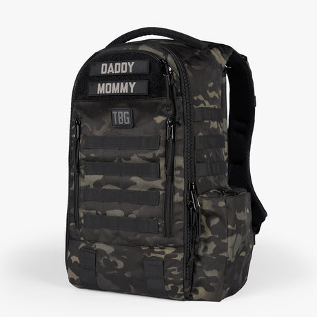 Camouflage tactical daypack diaper bag with multiple compartments, adjustable straps, and labeled for parents.