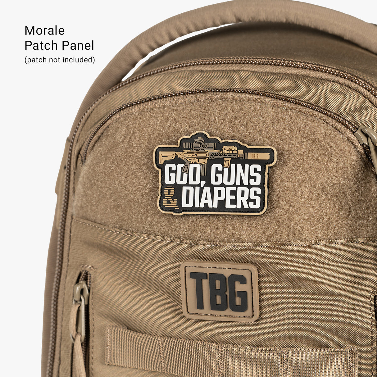 Tan tactical daypack diaper bag with patches reading God Guns Diapers and TBG, designed for parents on the go.