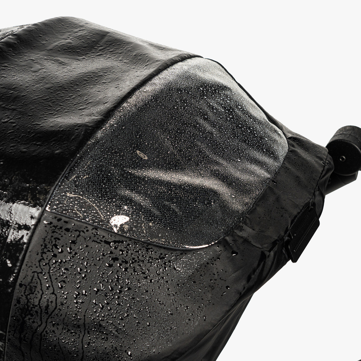 Close-up of the S-1 Rain Cover showing a waterproof design with droplets on the surface, ideal for protecting gear.
