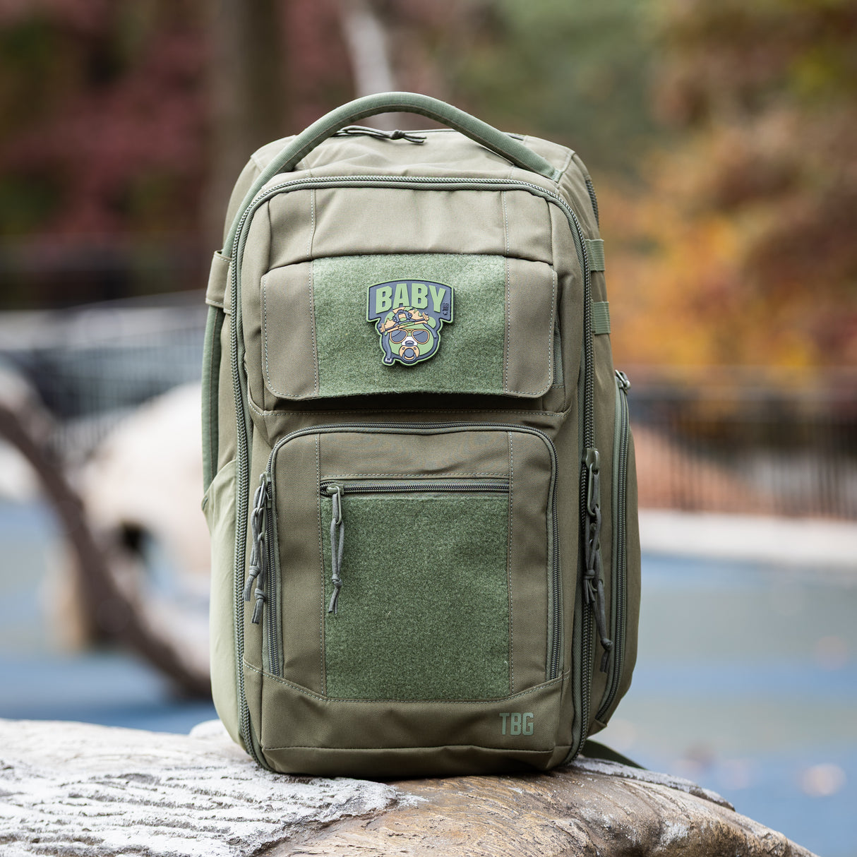 Rugged green baby backpack featuring a Baby Bear patch, designed for modern parents on the go.