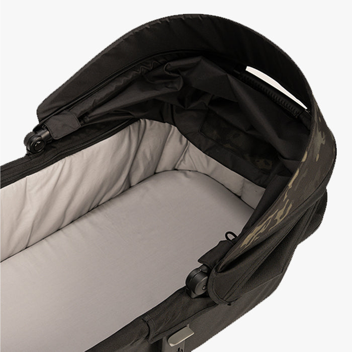 Black and camo baby carrier with a hood, featuring sturdy zippers and adjustable straps.