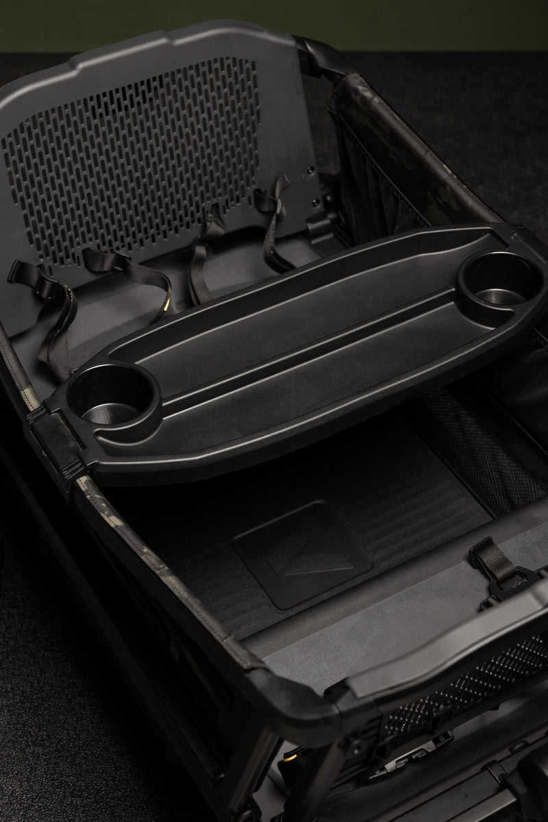 Black military-style stroller collapsed inside a durable case, featuring robust handles and textured surfaces.
