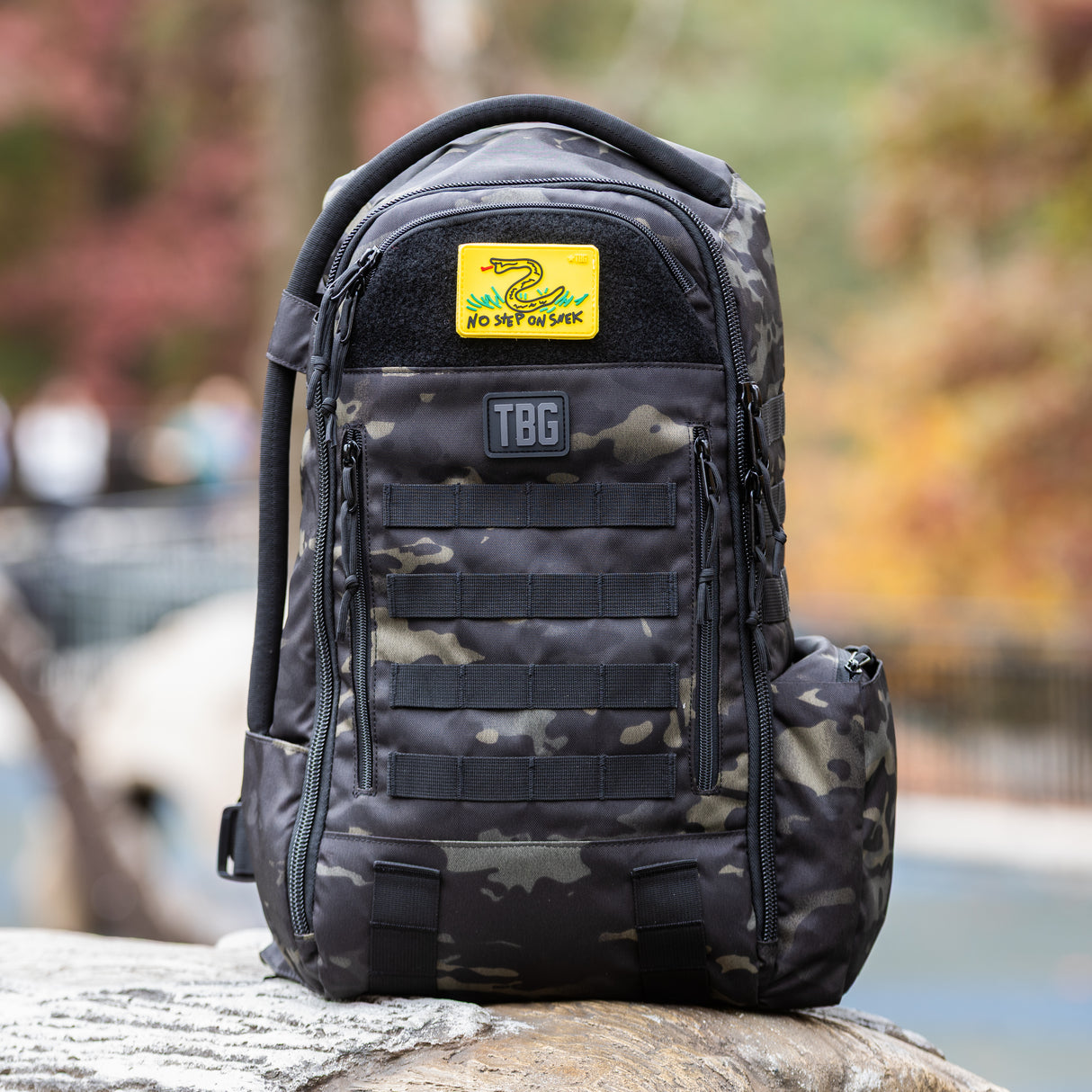 Tactical Baby Gear backpack featuring a "No Step On Snek" patch on a camo design, ideal for rugged parenting adventures.