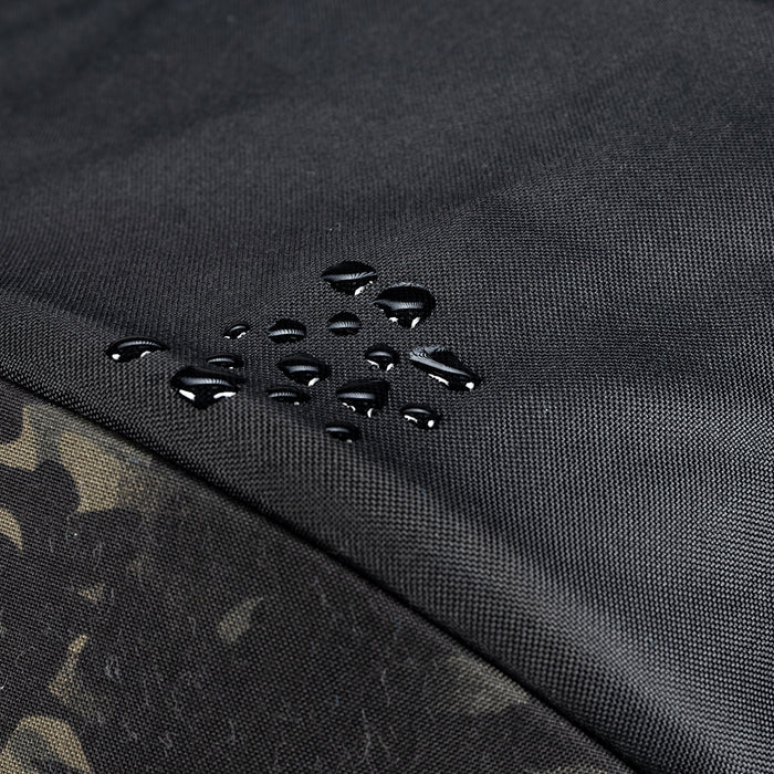 Close-up of black water-resistant fabric with a camouflage pattern edge.