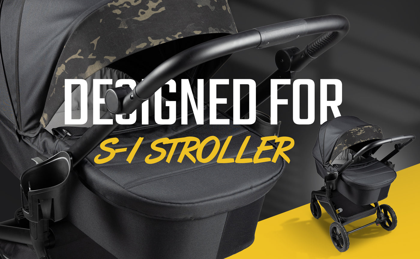 Black and camouflage baby stroller with ergonomic handle on a yellow background.