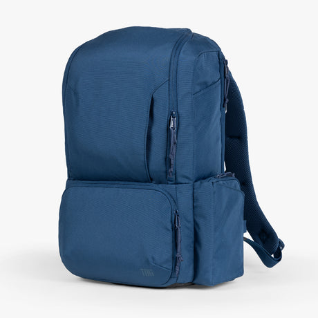 Blue expedition diaper bag displayed against a plain background, featuring multiple compartments and adjustable straps.