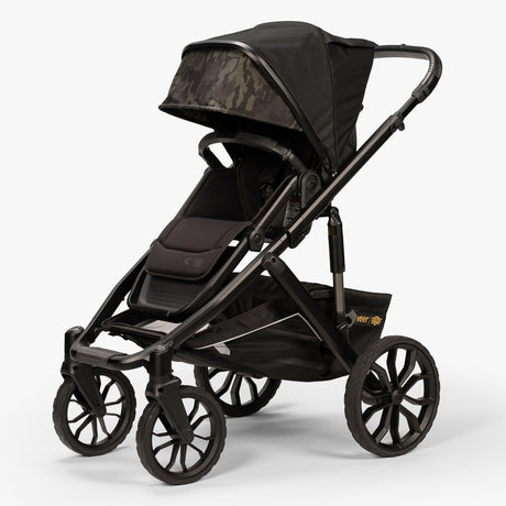 Front three-quarter view of TBG Veer Switchback Stroller with canopy extended, parked outdoors.