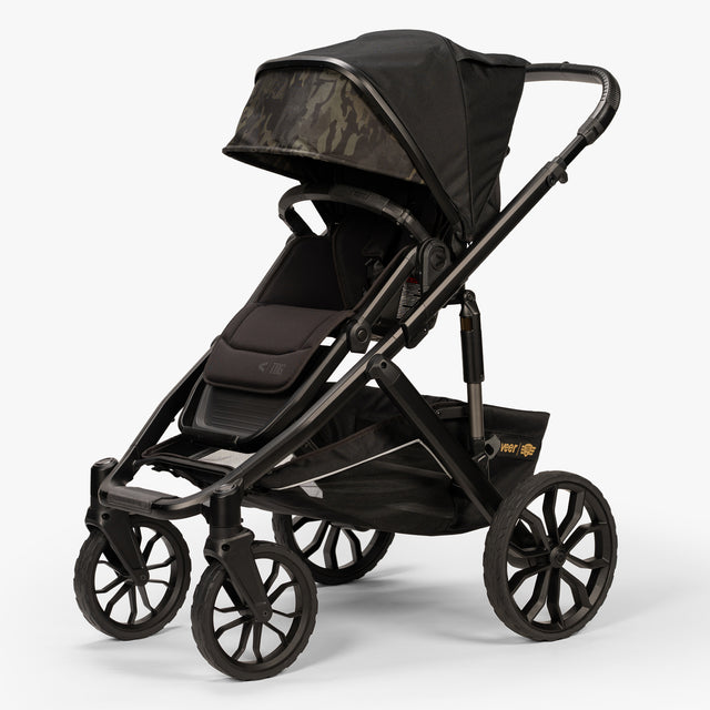 Front three-quarter view of TBG Veer Switchback Stroller with canopy extended, parked outdoors.