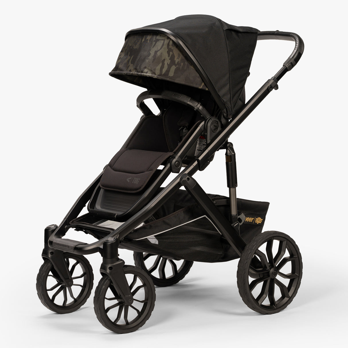 Baby wearing carrier in gray with a canopy, showing a 3/4 front view, marketed as TBG Veer Switchback Newborn Bundle.