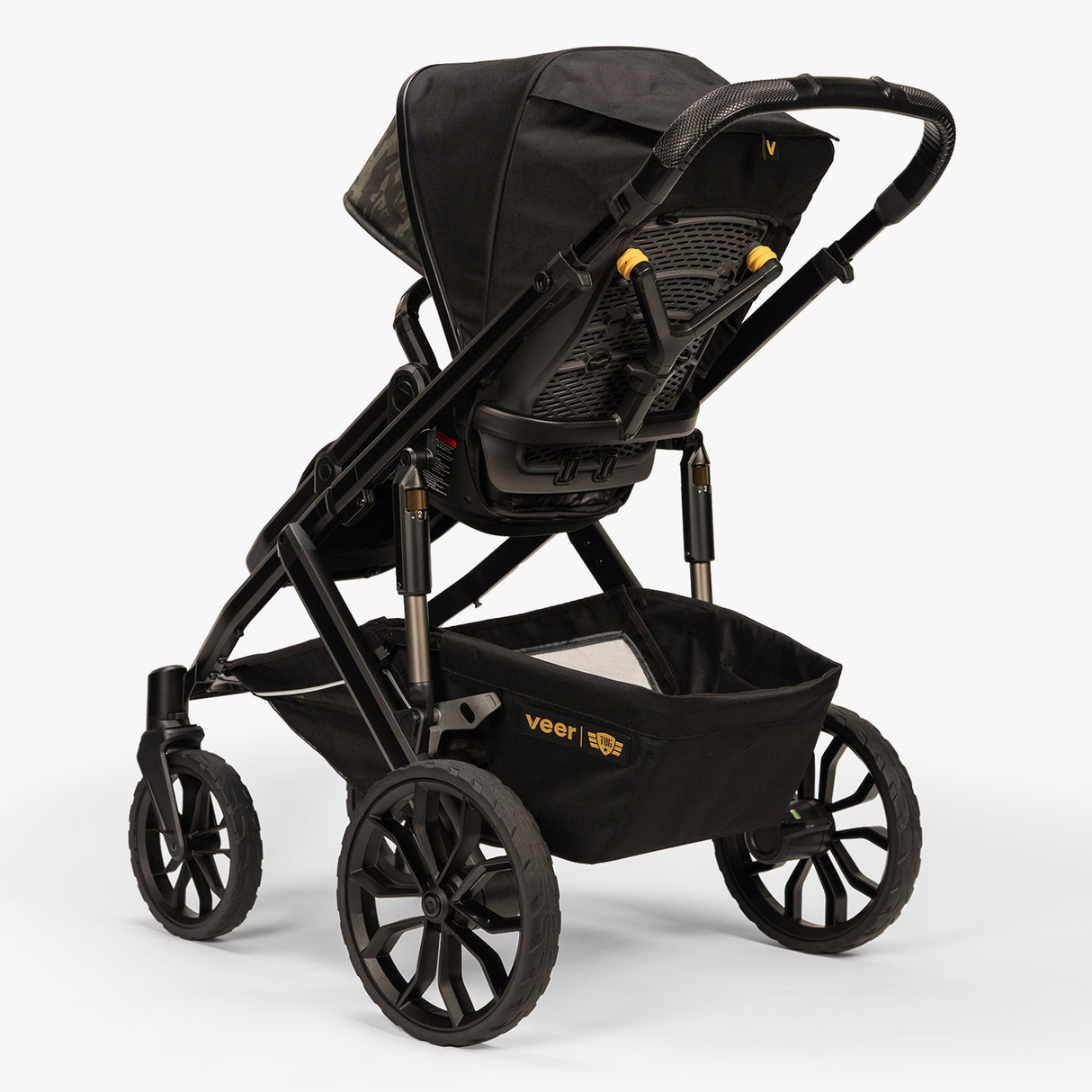 Rear three-quarter view of the TBG Veer Switchback Stroller showing its wheels and handle.