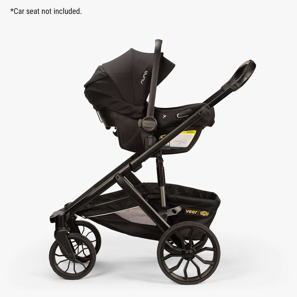 Side view of TBG Veer Switchback Stroller with a car seat attached, positioned outdoors.
