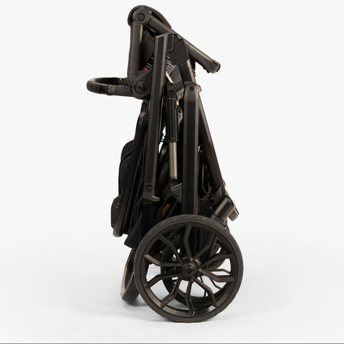Compact, foldable baby stroller from TBG | Veer Switchback Newborn Bundle, shown from the side, in a neutral color.