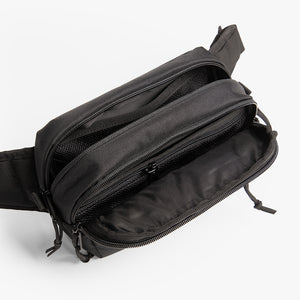 Top view of fanny pack with pockets open to reveal storage space inside