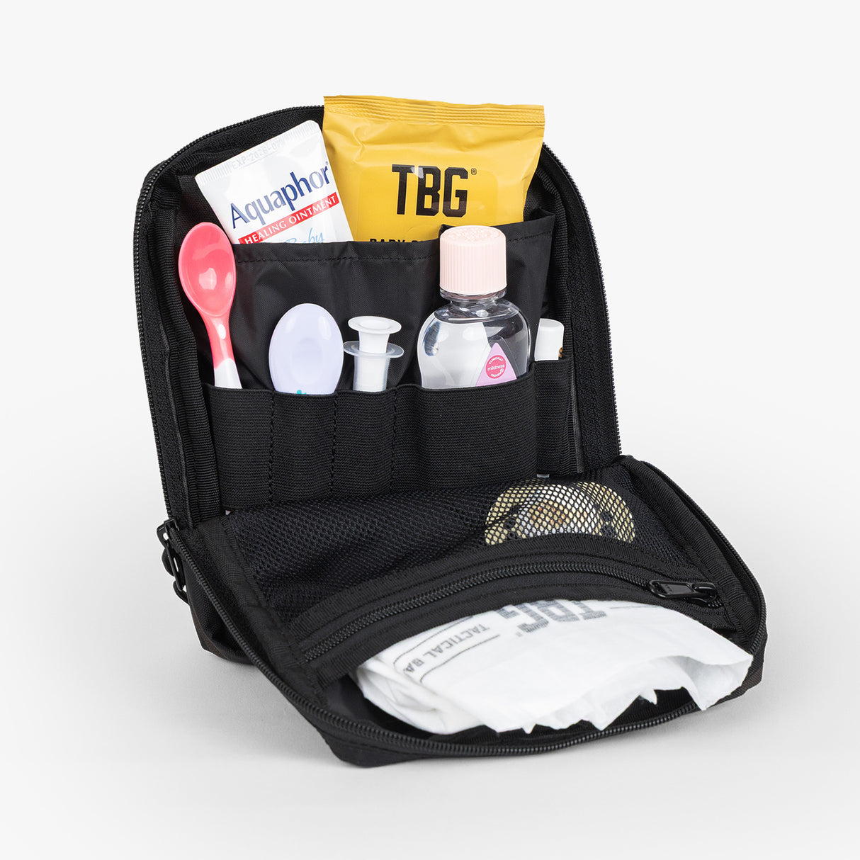 Open Tactical Utility Pouch displaying organized compartments with personal care items and a small bottle.