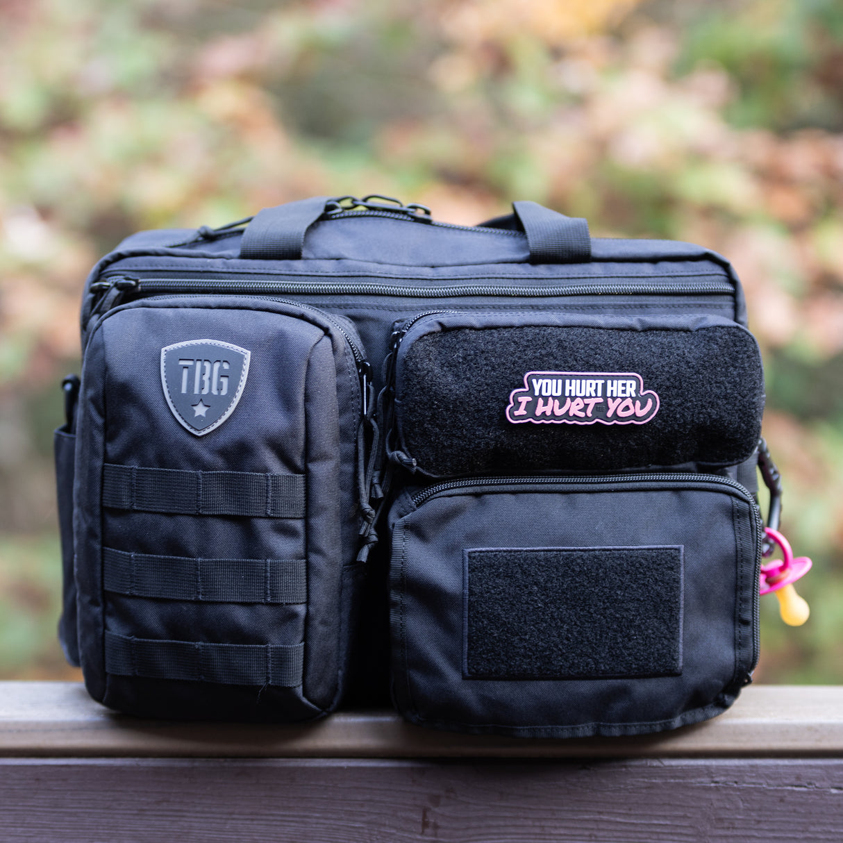 Tactical Baby Gear diaper bag featuring a "You hurt her, I hurt you" patch, designed for rugged parenting.