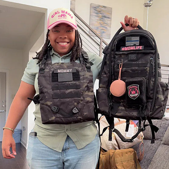 Female police officer wearing baby carrier and holding diaper bag