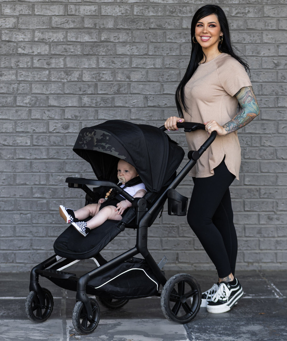 happy mom standing with tactical baby gear stroller