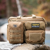 Tactical Baby Gear bag featuring a "Trophy Husband" patch, designed for rugged parenting and outdoor adventures.