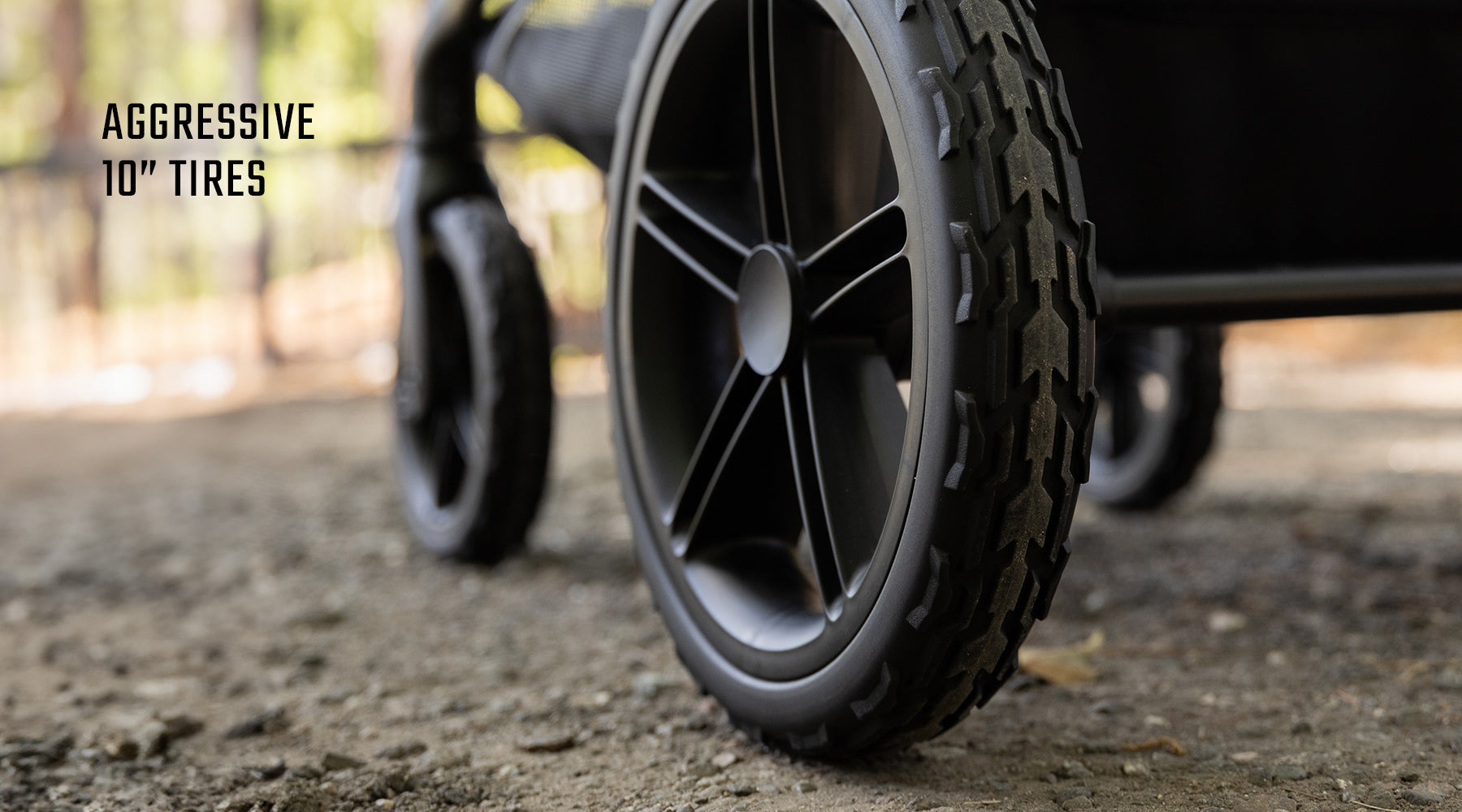 Close-up of rugged black stroller wheels with aggressive 10-inch tires, suitable for outdoor adventures.