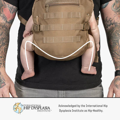 Man wearing a tan, military-style baby carrier with adjustable straps.