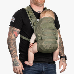 Man wearing ranger green baby carrier with infant facing in 