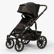 Front three-quarter view of TBG Veer Switchback Stroller with canopy extended, parked outdoors.