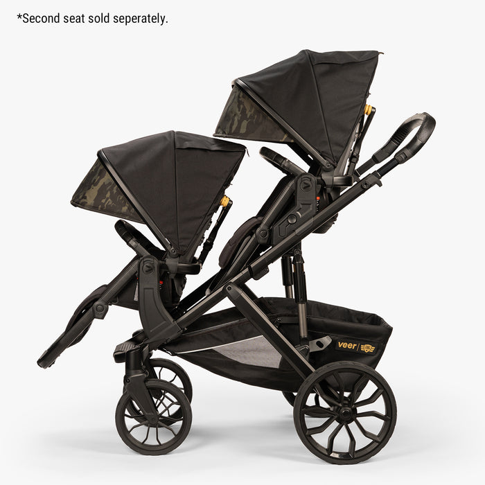 Double stroller in black with camouflage canopy and rugged wheels, labeled "Veer".