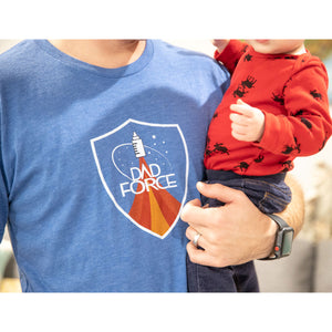 Man holding child while wearing blue dad force t-shirt. 