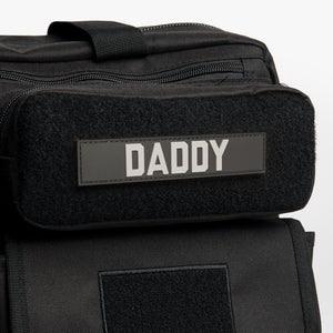 Black name tape DADDY patch on black diaper bag backpack.