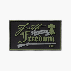 Black patch with gray and green text reading Faith, Family, Freedom, over gray colonial era rifle. 