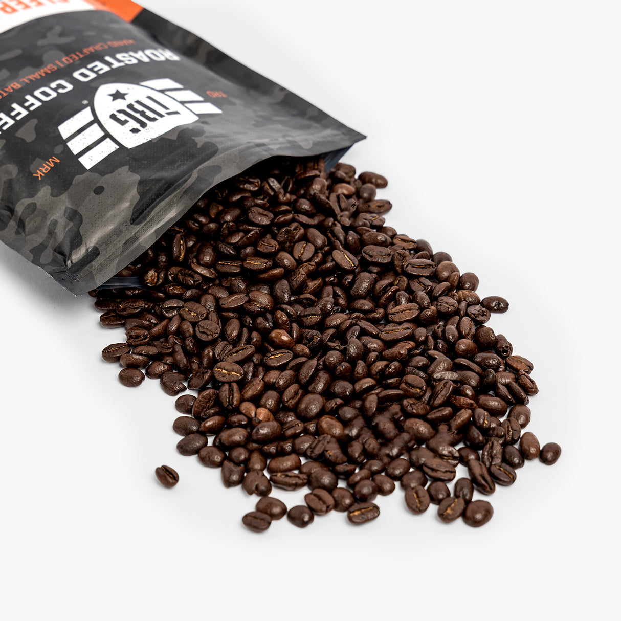 Black roasted coffee beans spilling from a military-inspired, rugged black and orange bag.