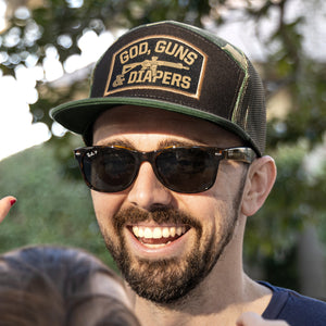 Man with sunglasses wearing Camo God, Guns & Diapers Hat