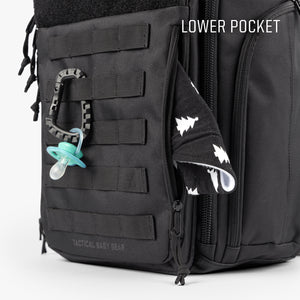Close up of black MOD backpack with panel 5 attached and carabiner clip holding pacifier