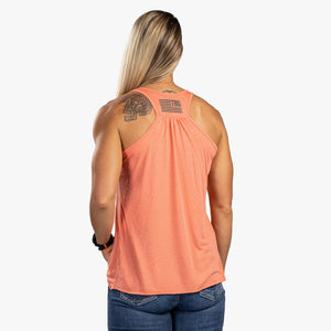 Rear view of woman wearing coral tank top with TBG flag. 