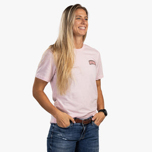 Front view of woman wearing soft pink t-shirt with small mama on top left.