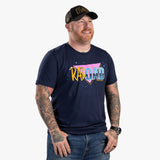 Men's navy T-shirt with colorful "RAD DAD" graphic, tattooed arms, and a black trucker hat with military-inspired patch.