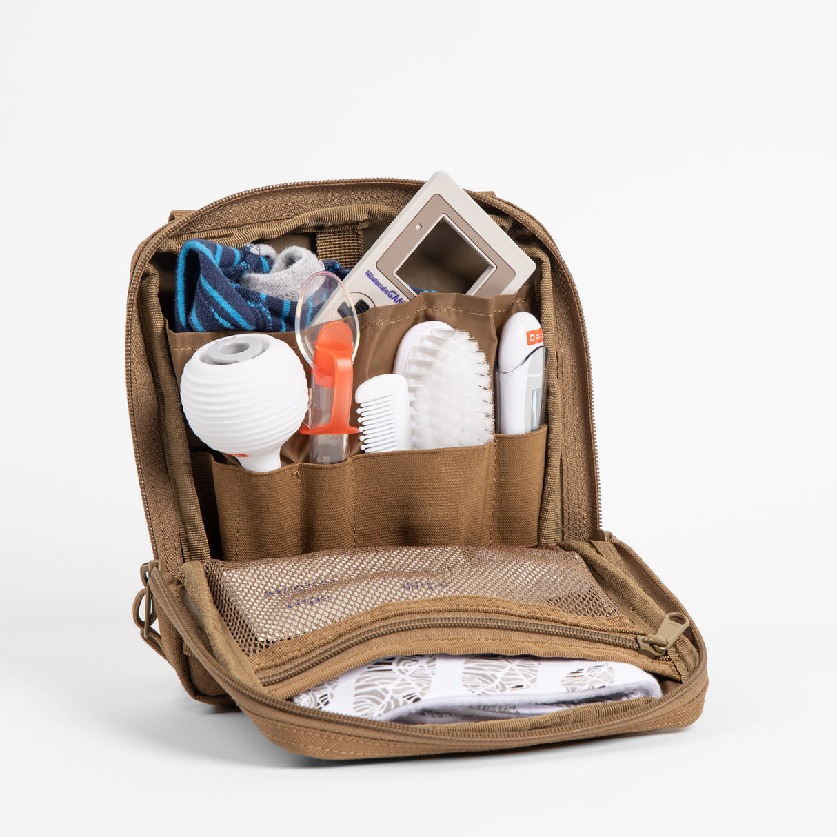Rugged tan parenting organizer with multiple compartments holding baby essentials like a thermometer, brush, socks, and toys.